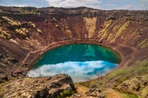 Vibrant blue lake inside the red volcanic crater of Kerid in South Iceland