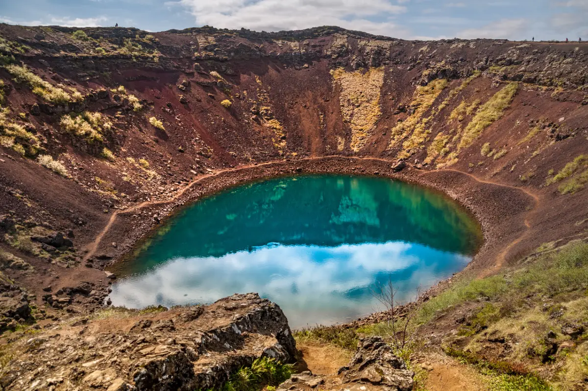 Vibrant blue lake inside the red volcanic crater of Kerid in South Iceland