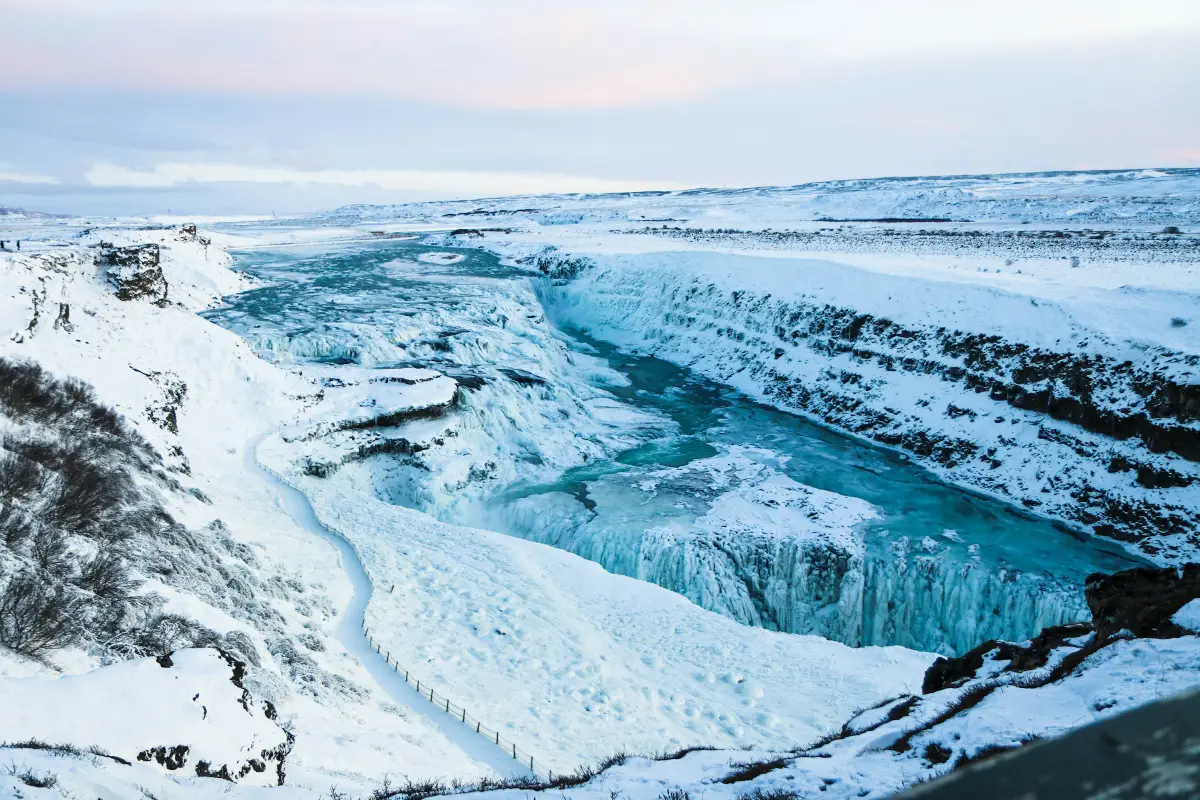 Snow-covered Gullfoss waterfall and canyon in winter with icy blue water flowing between white slopes