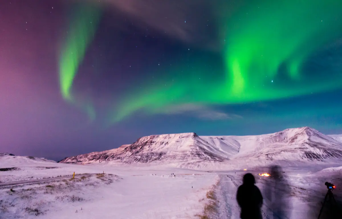 Aurora borealis above snow-covered mountains in Iceland on a winter night
