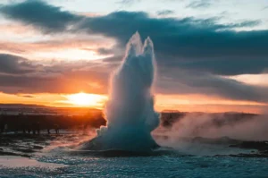 Strokkur geyser erupting at sunset on a winter day in Iceland