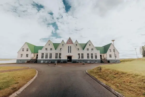 Hérðasskólinn Historic Guesthouse, a large white heritage building overlooking Laugarvatn lake