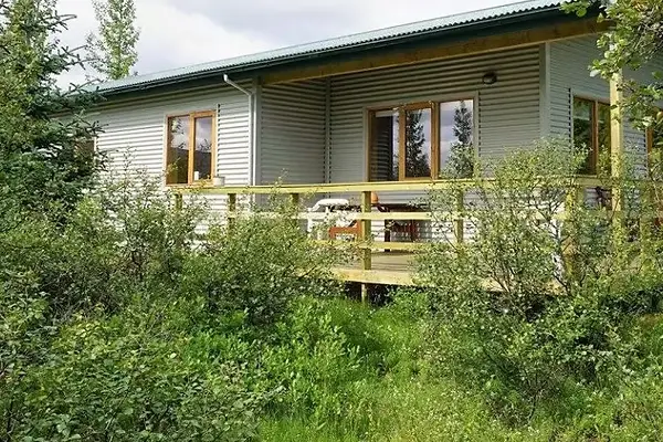 Miðdalsskot is a rural cottage with a red roof surrounded by quiet Icelandic countryside