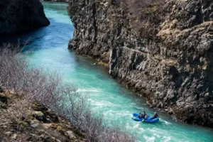 Rafting boat in turquoise glacial river canyon near Gullfoss waterfall