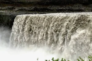 Close-up of Dettifoss waterfall with powerful white water plunging over a dark canyon edge