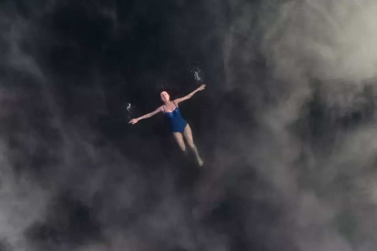 Aerial view of woman floating in the Secret Lagoon hot spring in Iceland