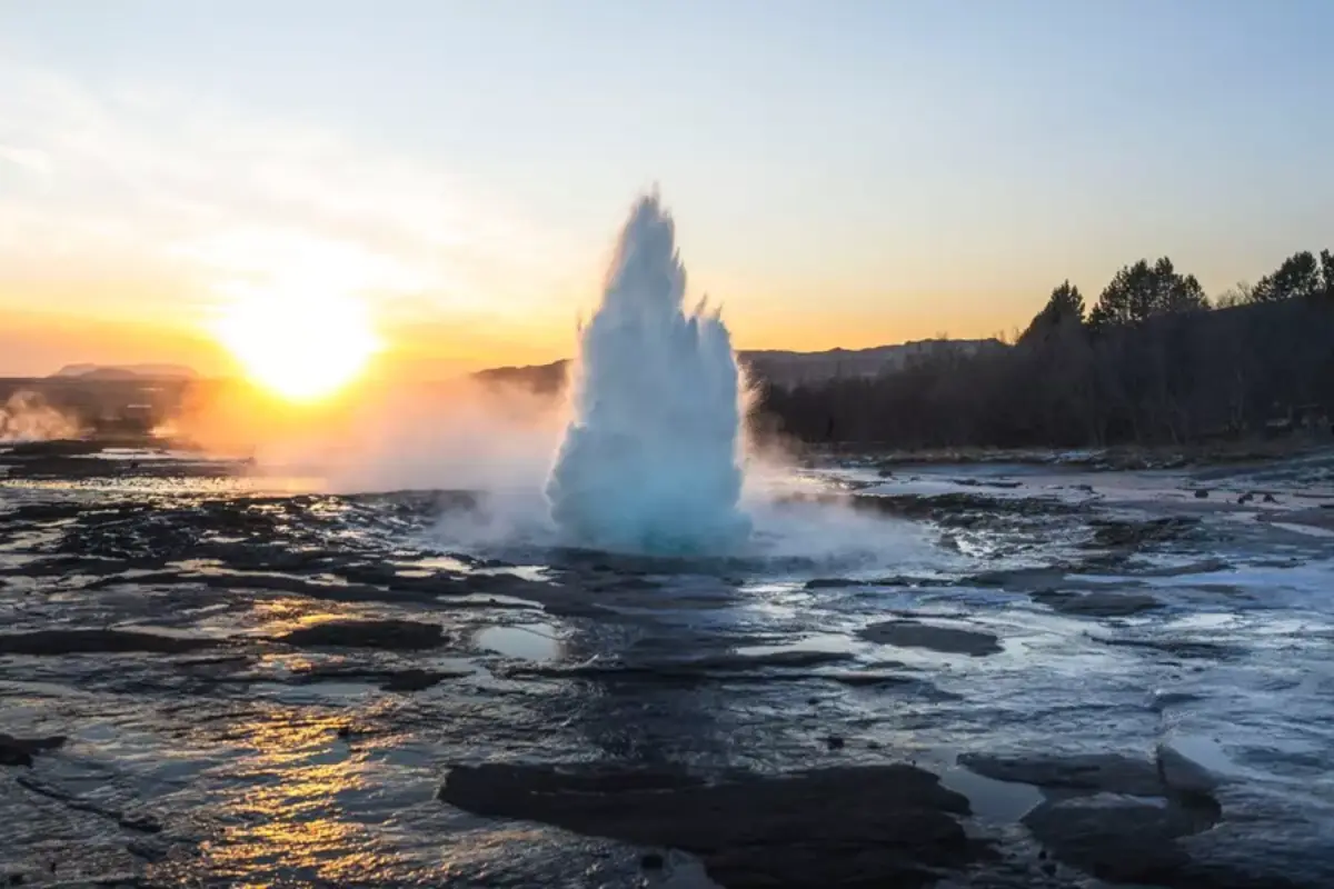 Strokkur geyser erupting at sunset in the Geysir geothermal area