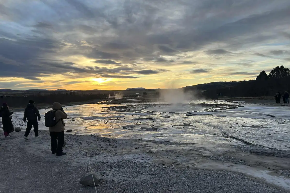 Steam rises from the geothermal ground at Geysir as visitors explore this iconic Golden Circle stop.
