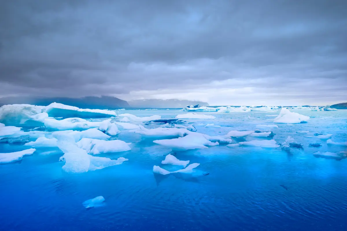 Floating icebergs in Jökulsárlón Glacier Lagoon under a cloudy sky in South Iceland.