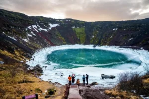Small group visiting Kerið crater lake in winter, Iceland