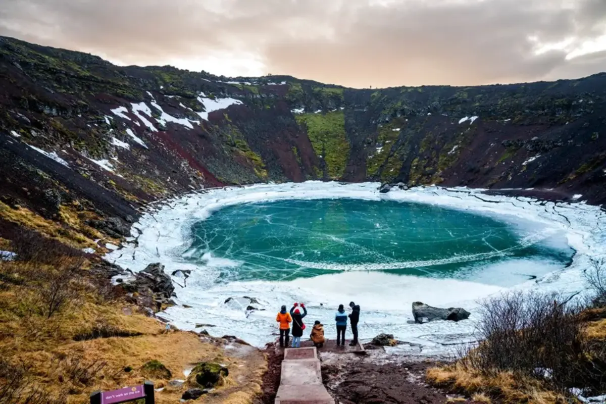Small group visiting Kerið crater lake in winter, Iceland
