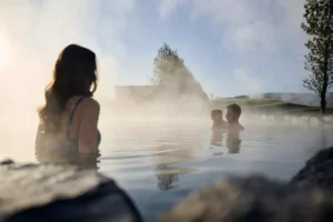 Family enjoying the Secret Lagoon geothermal pool in Flúðir, Iceland