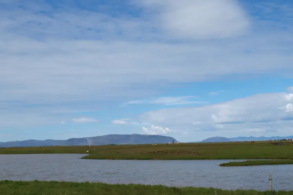 View of Ingólfsfjall mountain across a river and open fields in South Iceland