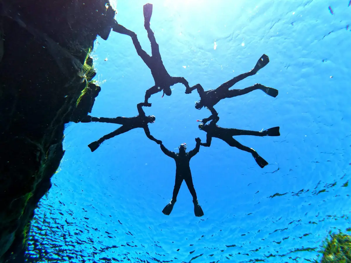 Snorkelers exploring the crystal-clear waters of Silfra fissure in Iceland