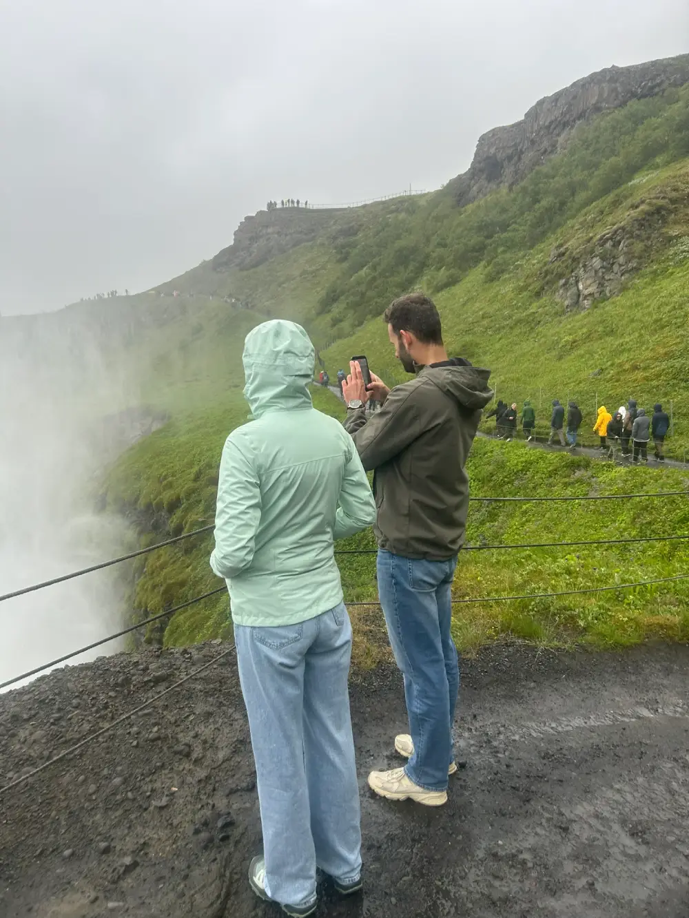 Couple taking a photo overlooking the Gullfoss waterfall canyon